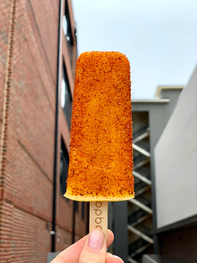 Mango vegan sorbet popsicle topped with chilly powder